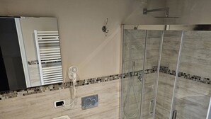 A modern bathroom with a glass-enclosed shower, a sink with a vanity, and a toilet. - Beautiful Central Apartment (Firenze)