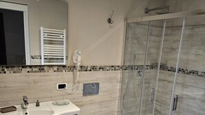 A modern bathroom with a large sink, vanity, and a glass shower enclosure. - Beautiful Central Apartment (Firenze)