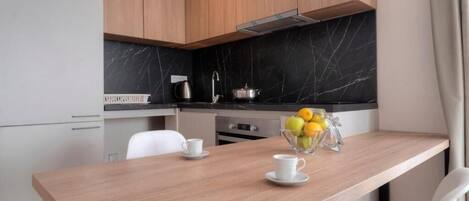 A modern kitchen with wooden cabinets, a marble backsplash, and a dining table with chairs.