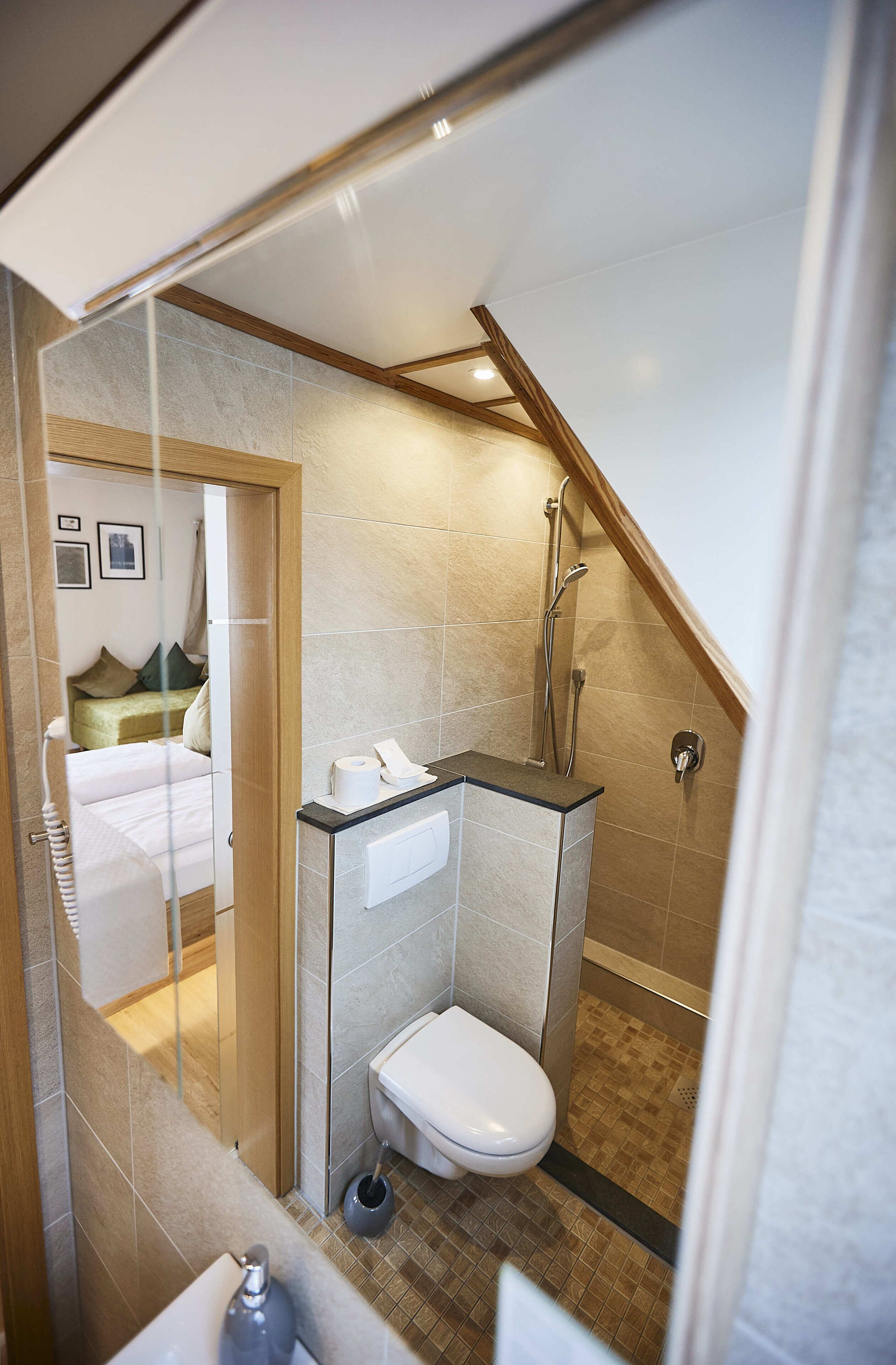 A compact bathroom with a shower, toilet, and a small sink.