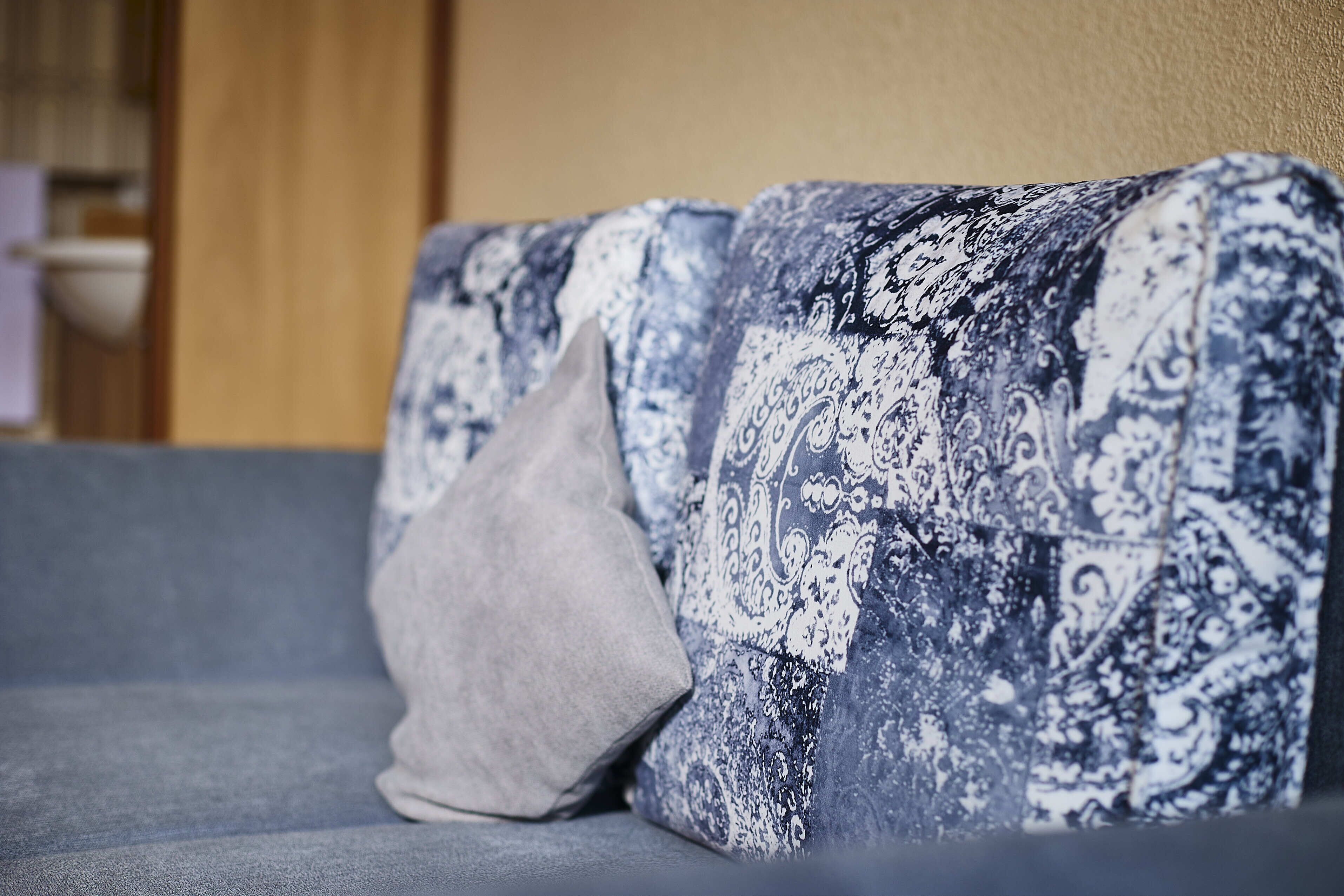 Un canapé avec des coussins à motifs et un coussin uni.