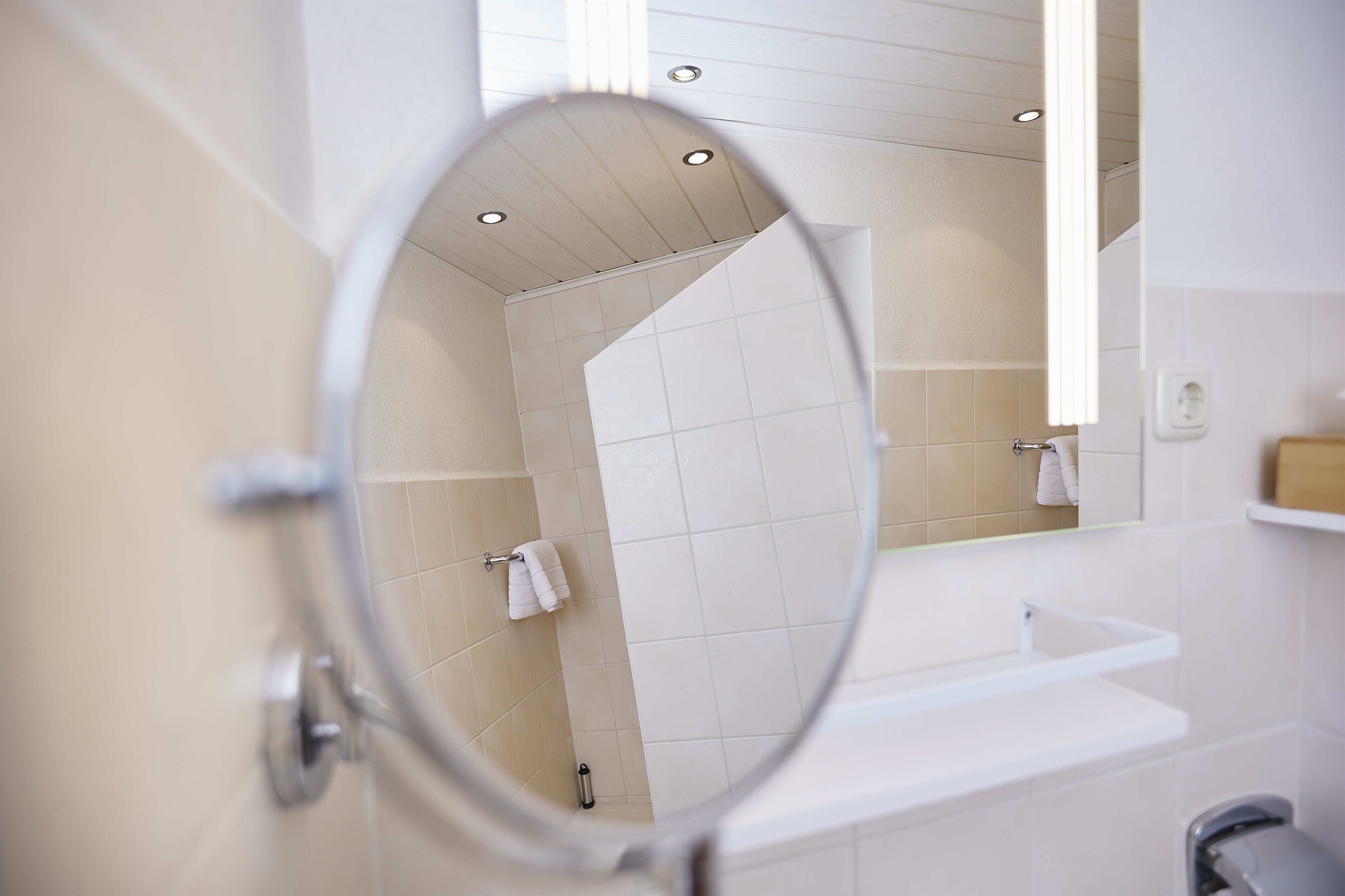 A bathroom with a white sink, a mirror, and a towel rack.