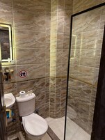 Ein Badezimmer mit Toilette, Waschbecken und Duschbereich.