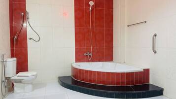 A bathroom with a bathtub, toilet, and shower.