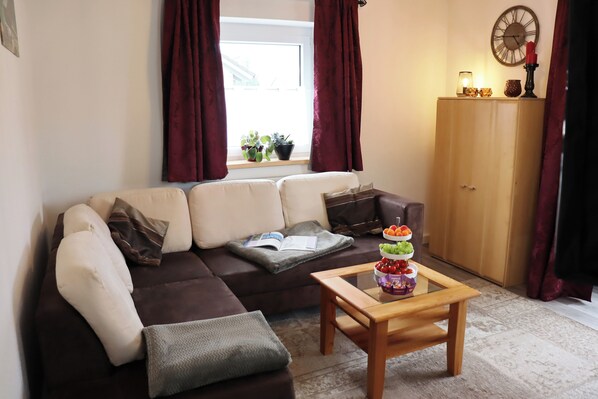 Relax in this inviting living room with a sofa, coffee table, and wooden cabinet.