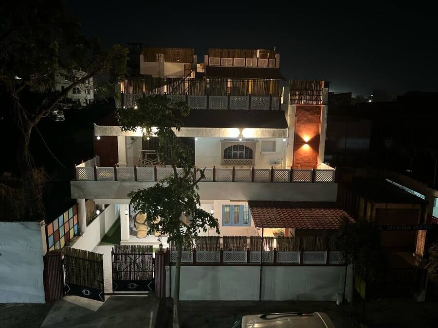 Un edificio de varios pisos con un balcón y una entrada iluminada.