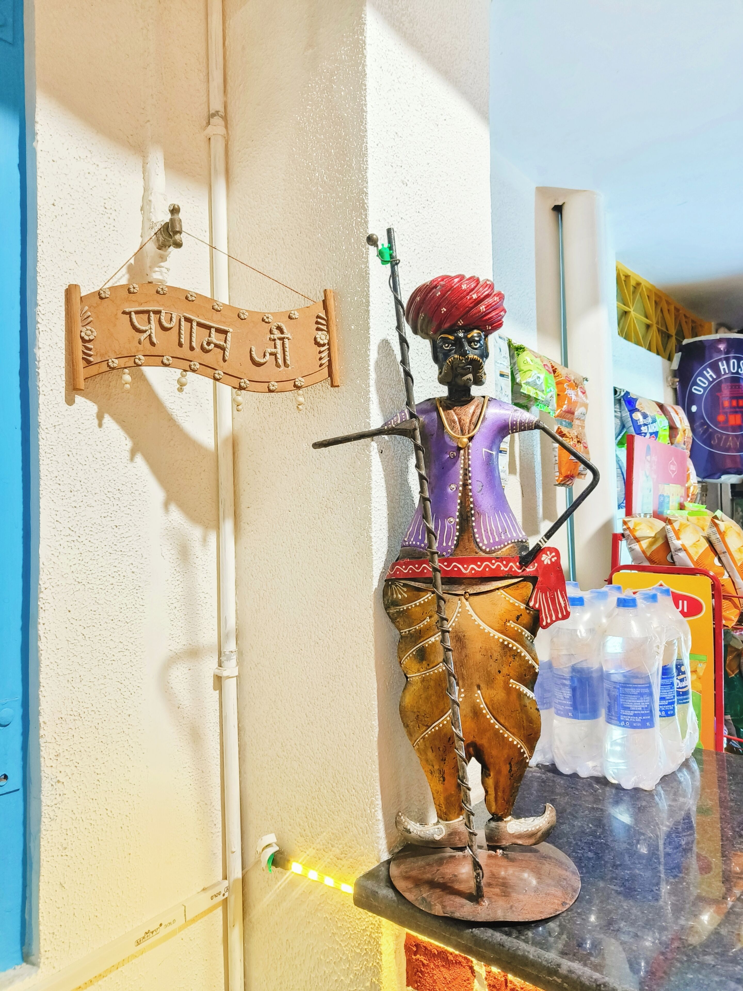 Een standbeeld van een traditionele figuur, met een bord erboven met de tekst 'Prayag'.