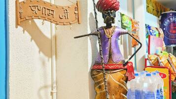 Een standbeeld van een traditionele figuur, met een bord erboven met de tekst 'Prayag'.