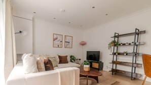 Apartamento básico, várias camas | Área de estar | TV