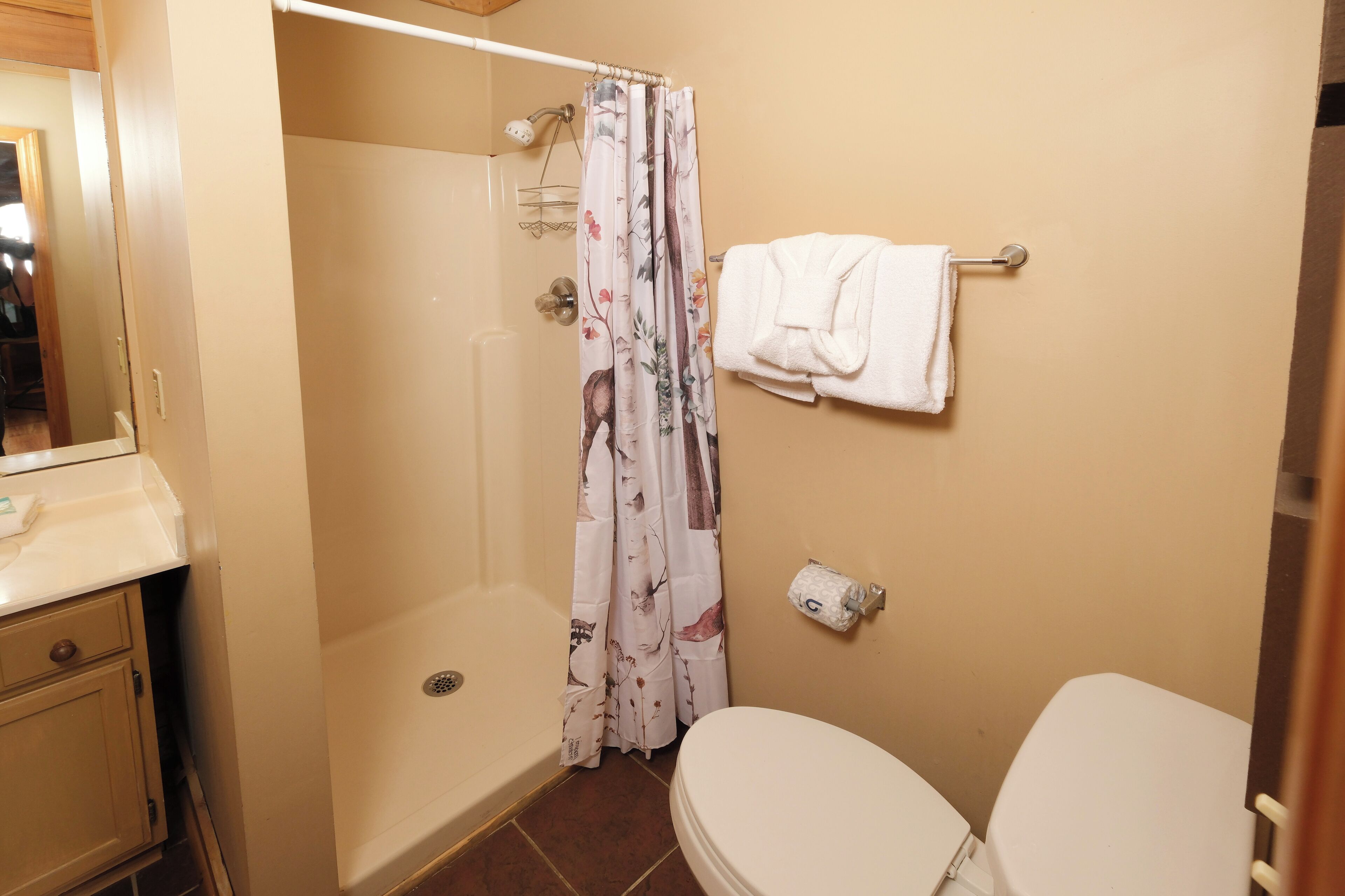 Une salle de bain avec une douche, des toilettes et un porte-serviettes.