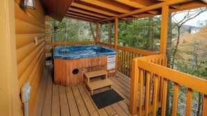 A wooden deck with a hot tub, wooden steps, and a railing. - 2BR GBurg log cabin- hot tub, dog friendly! (Gatlinburg)