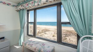 A room with a large window, a bench, and a small table. - Beautiful 2BD/2 Bathroom direct ocean front located closer to downtown . (OCEAN CITY)