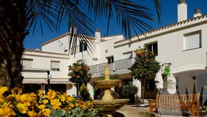 A courtyard with a fountain, benches, and potted plants. - La Manga Club Bellaluz Apartment 603 (Atamaría)