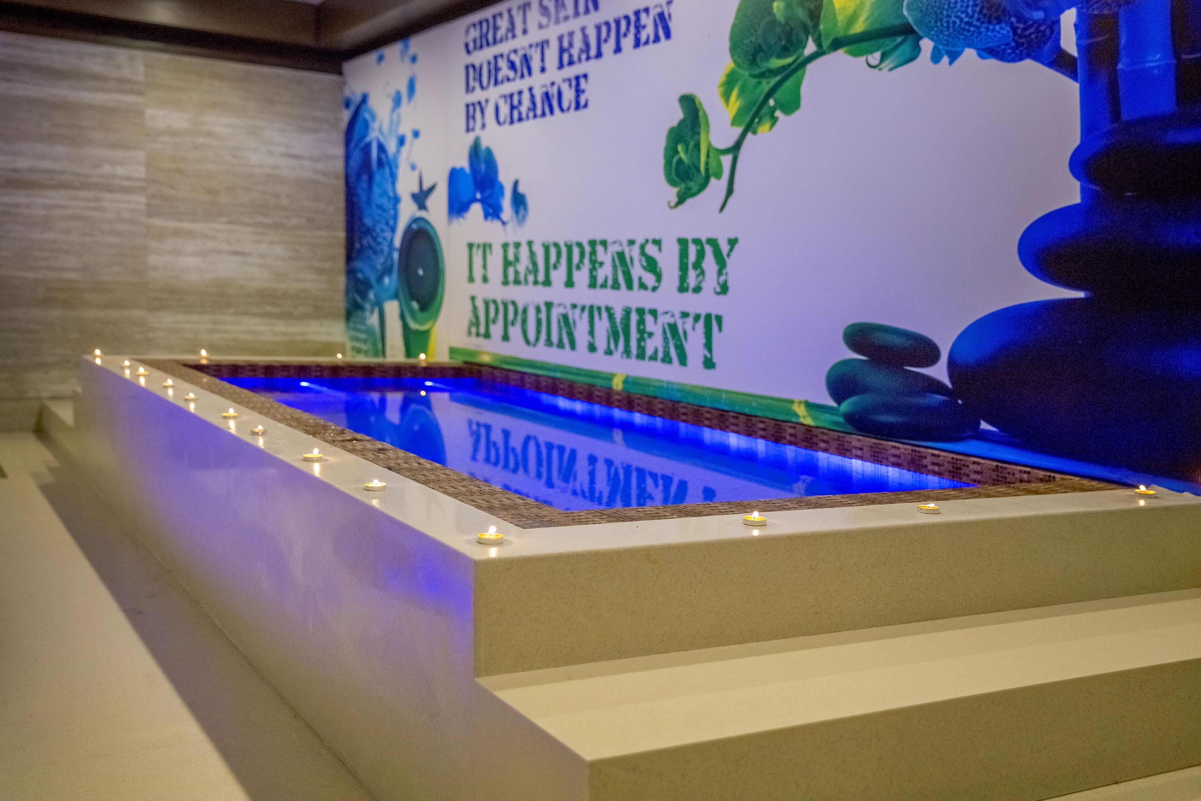 A spa area with a water feature, candles, and a wall with motivational text.