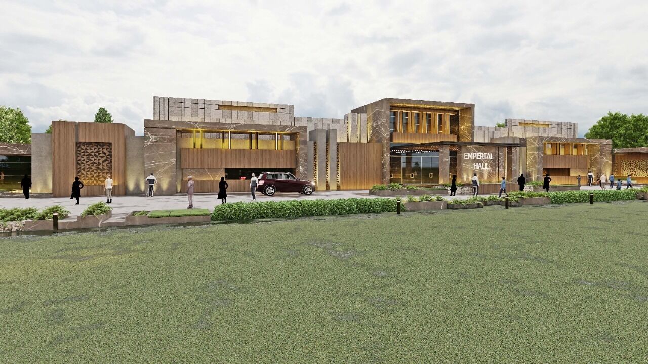 Un bâtiment moderne doté d’une grande entrée, d’une enseigne indiquant « EMPERIAL HALL », et d’un parking où sont stationnées quelques voitures.