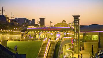 A stadium with a terrace BBQ, stadium seating, and a large field.