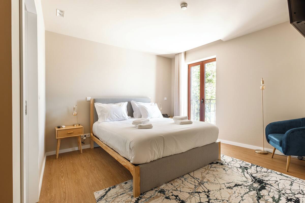 A bedroom with a bed, bedside table, and a floor lamp.