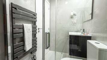 Un bagno moderno con box doccia in vetro, un water e un lavandino.