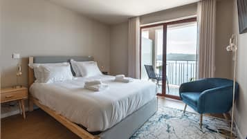 Een hotelkamer met een bed, een stoel, een bureau en uitzicht op de omgeving.