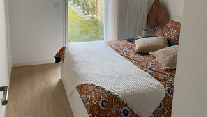 A bedroom with a bed, a window, and a view of the outside. - Cancoon - Holiday Apartment Rental Cancale (Cancale)