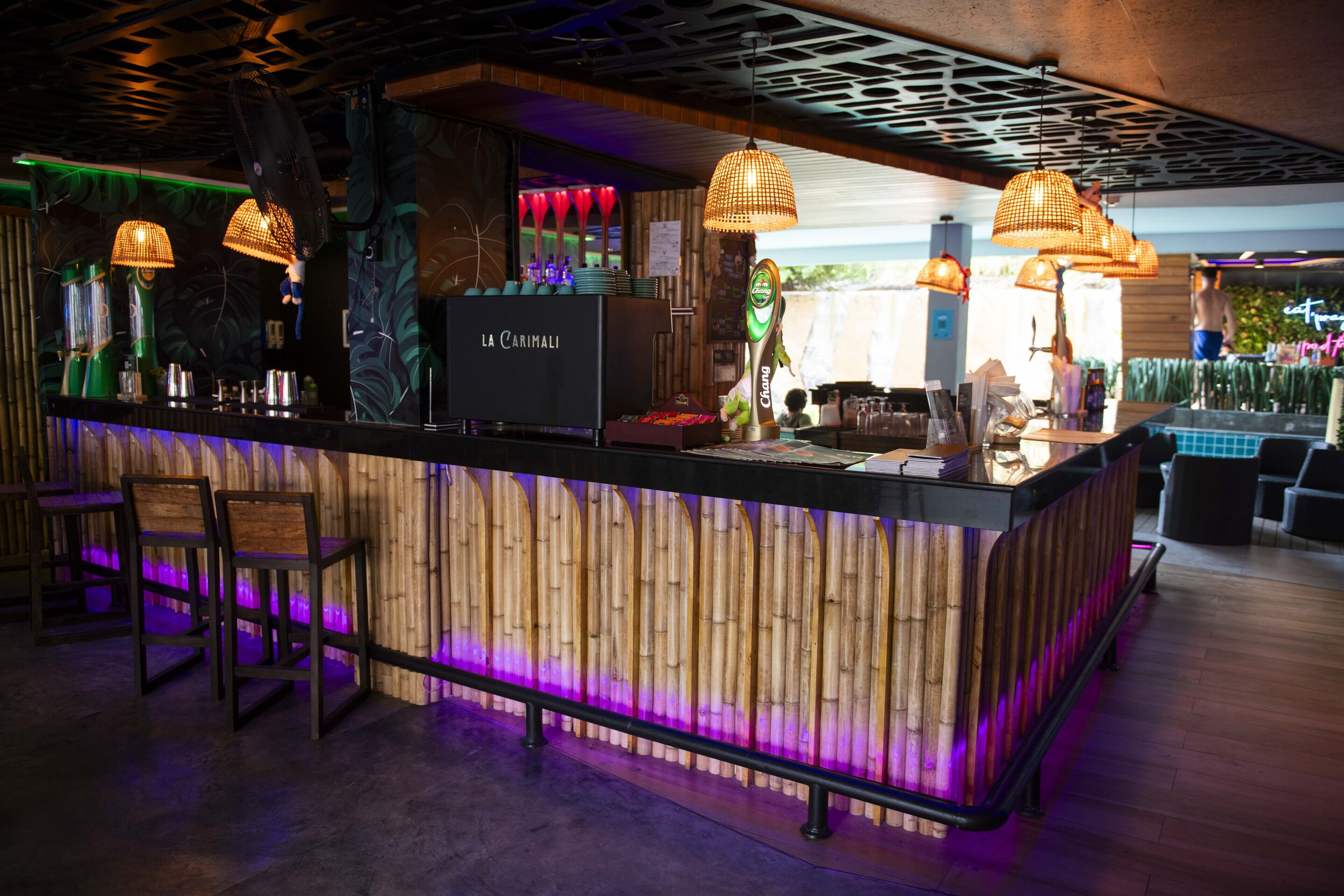 Un espace bar décoré dans un style inspiré du bambou, comprenant un comptoir et des sièges.