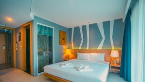 Ein Hotelzimmer mit einem großen Bett, zwei Nachttischen mit Lampen, einem Holz-Kopfteil und einer Wand mit geometrischem Muster.