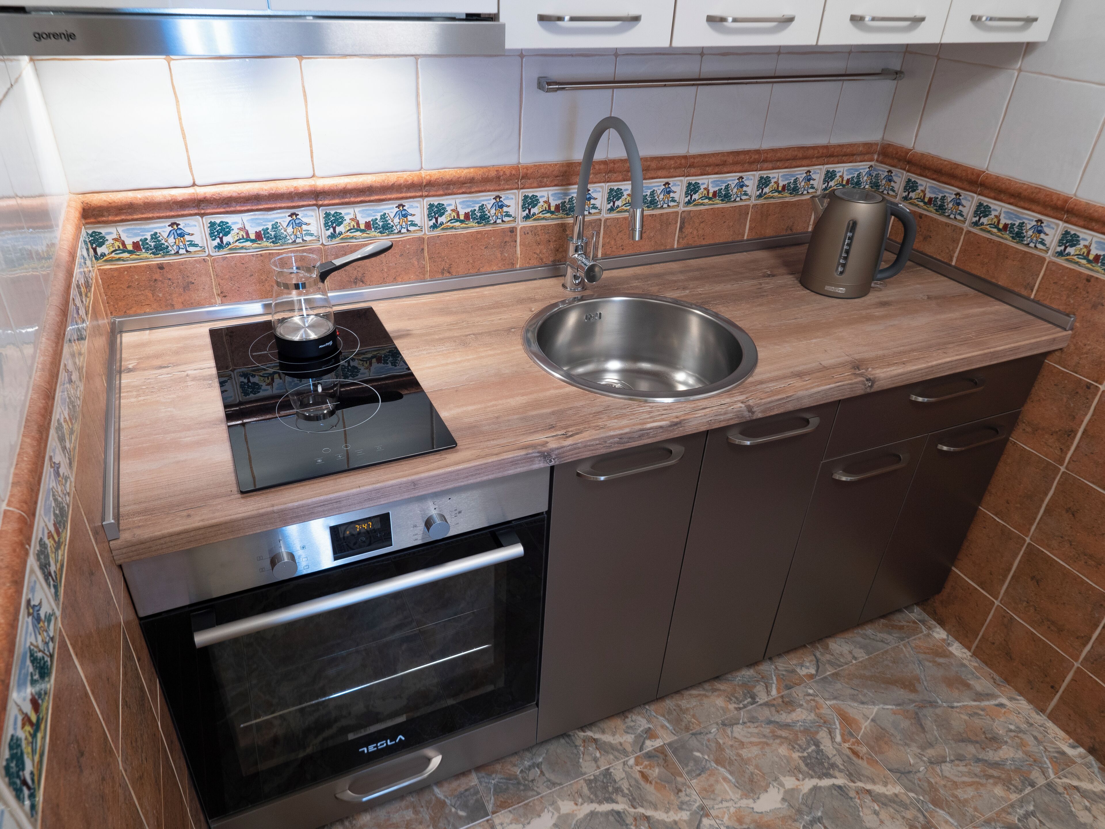 A kitchen with a built-in stove, sink, and oven.