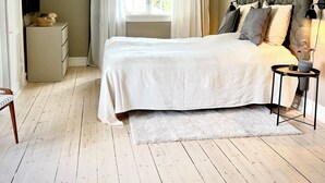 A bedroom with a bed, a nightstand, a dresser, a window with curtains, and a ceiling light. - Beautiful Villa, 150 m2 activity hall with tabletennis etc. outdoor 6 pers. spa (Taastrup)
