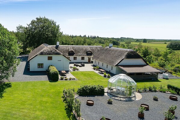 A large, white building with multiple rooms and a covered outdoor area. - Schellerup Gård (Herning)