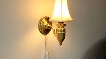A wall-mounted lamp with a white shade and a brass base.