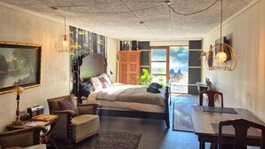 A bedroom with a bed, a chair, a table, and a painting on the wall. - Schellerup Gård (Herning)