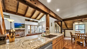 A spacious kitchen with granite countertops, wooden cabinets, and a built-in dishwasher.