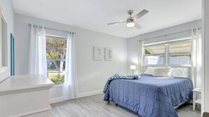 A bedroom with a bed, a ceiling fan, and a window with curtains. - Bungalow Close to Naples Beaches (Naples)