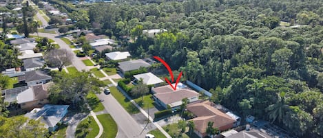 Una vista aerea di una zona residenziale con case, strade e vegetazione.