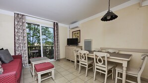 Un comedor con una mesa, sillas, un televisor y un sofá.