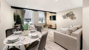 A modern living room with a dining area, a sofa, and a TV. - Host & Stay | Halifax House Living (Liverpool)