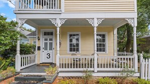 Una casa a due piani con un portico, una porta d'ingresso con la scritta '311' e un piccolo giardino con delle scale che conducono all'ingresso.