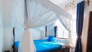A bedroom with a canopy bed, a ceiling fan, and a view of the outside. - Villa m. Pool, Tropischen Garten & ca 7 Minuten zum Herrlichen Weißen Sandstrand (Msambweni)