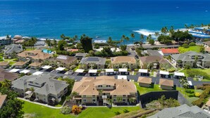 A coastal residential area with houses, a swimming pool, and a view of the ocean.