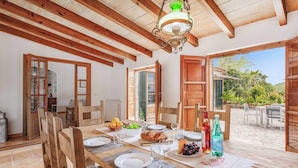 Ein Essbereich mit einem Holztisch, gedeckt für eine Mahlzeit, umgeben von Stühlen.