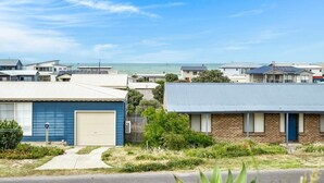 A residential area with houses, a clear sky, and a view of the ocean.
