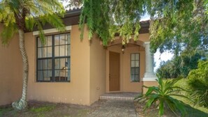 A house with a paved entrance, a large window, and a door. - This vacation rental home offers a spacious layout  (Rotonda West)