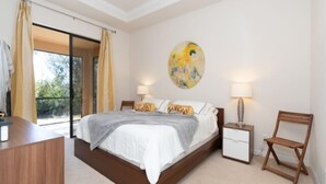A bedroom with a bed, bedside tables, a desk, and a window with curtains. - This vacation rental home offers a spacious layout  (Rotonda West)