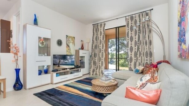 A modern living room with a sofa, TV, and decorative items. - This vacation rental home offers a spacious layout  (Rotonda West)