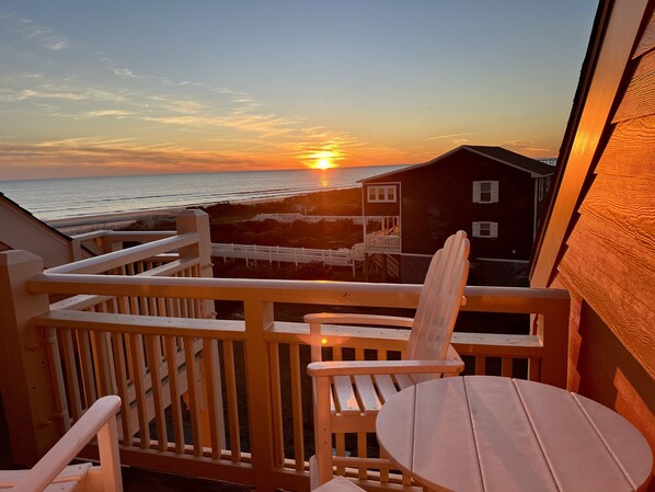 Enjoy breathtaking ocean views from this balcony with a bathtub and two comfortable chairs.