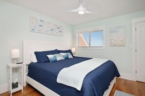 Cozy retreat with a large bed, nightstand, and ceiling fan.