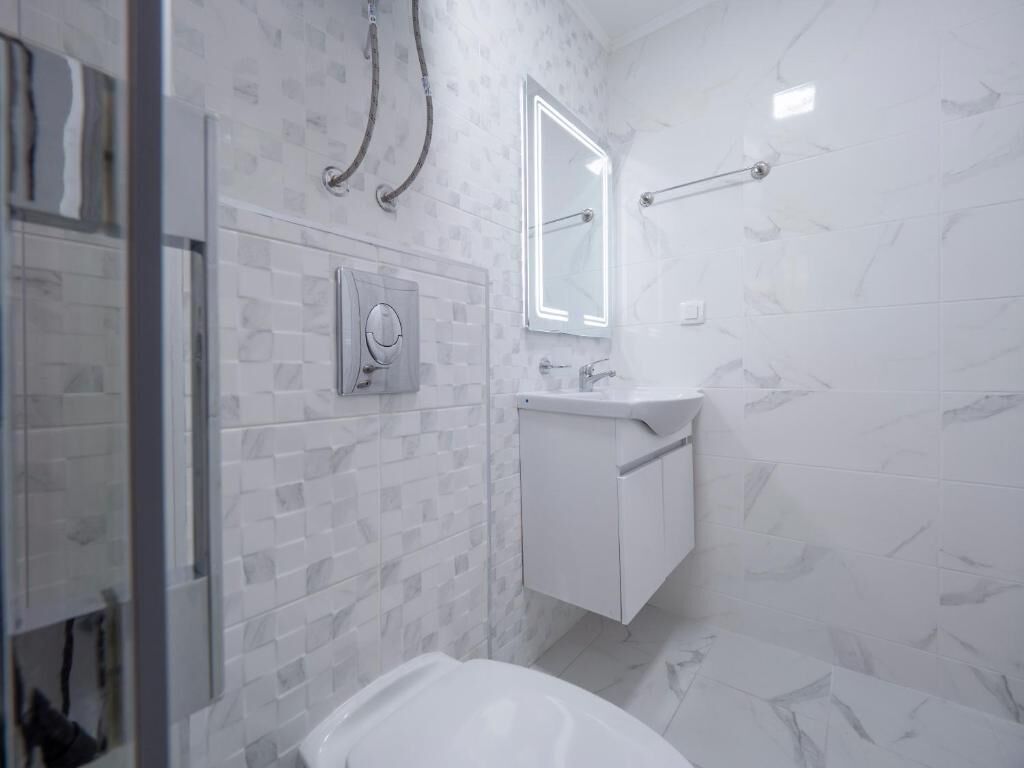 Ein Badezimmer mit Dusche, Toilette und Waschbecken.