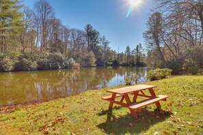 Ein Picknicktisch am See, umgeben von Bäumen.
