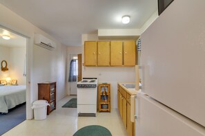 A compact kitchen with a stove, refrigerator, wooden cabinets, and a small sink. - Mountain Retreat w/ Loft, Fire Pit, & Grill (Delray)