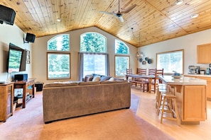 A spacious living room with a large sofa, wooden ceiling, and large windows. - Forest Views & Beach Access: Family Truckee Gem (Truckee)